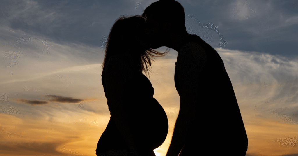 a pregnant couple in silhouette
